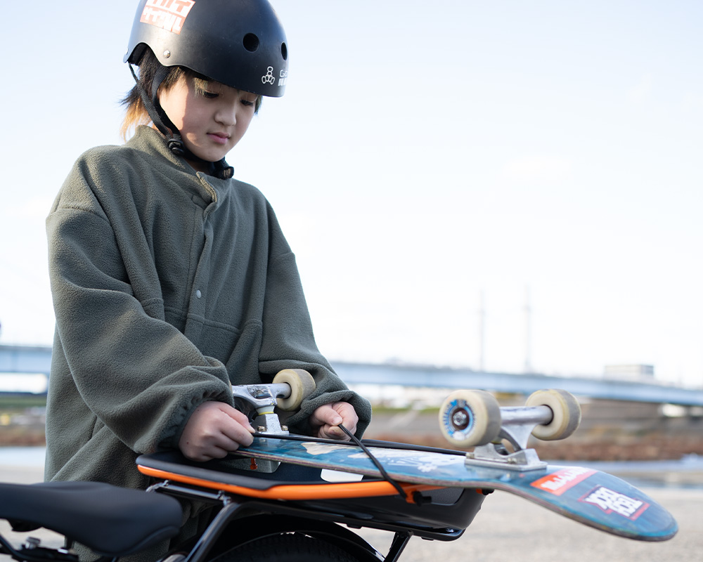 リアラックにスケートボードを積む河上恵蒔選手
